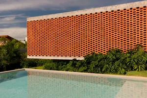 A brick wall with a textured appearance stands in front of a pool area with a reflective surface, creating a relaxing atmosphere