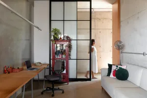 Modern living space with a white couch, chair, and table, a red cabinet, and two potted plants, set in a minimalist design with a focus on functionality and openness