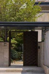 A serene entrance with a wooden door, surrounded by trees and bushes, creating a peaceful atmosphere