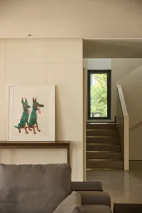 A warm and inviting living area with a wooden floor, featuring a painted dog mural and a framed dog painting, creating a cozy atmosphere
