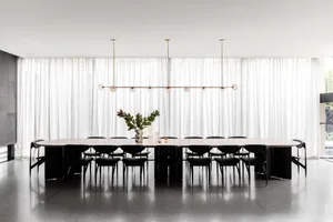 A calm and serene dining area with a long wooden table surrounded by chairs, set in a quiet space