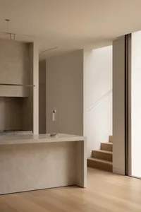 Open concept kitchen and living area with marble countertops, stainless steel oven, and large windows for natural light