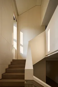 A well-lit staircase with wooden steps and a simple, elegant design