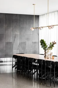Empty dining area with a long wooden table and multiple chairs, surrounded by a clean and minimalist space