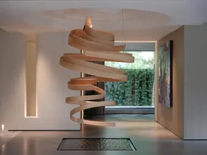 Open living space with a large wooden spiral staircase as the focal point, conveying a sense of spaciousness and elegance