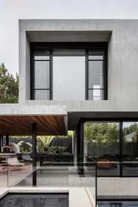 modern house with a large glass wall, concrete construction, and two windows