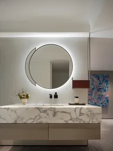 Luxurious bathroom with a marble countertop, sink, mirror, and decorative bottles and vase