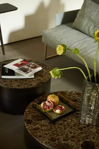 Cozy living room with a couch, coffee table, and various decorative items, including vases, fruit, and a potted plant, creating a warm and inviting atmosphere