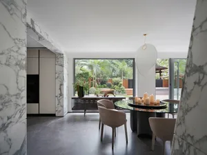 Open concept dining and kitchen space with a glass door, circular dining table, and modern kitchenette