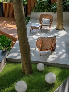 Relaxed outdoor seating area with chairs and couches arranged around a dining table, surrounded by natural surroundings