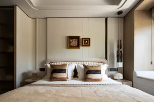 A cozy bedroom with a large bed, two pillows, and three pictures hanging above, creating a calm and relaxing atmosphere