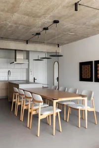 Cozy kitchen with a wooden dining table, chairs, and modern kitchen features like a sink and oven