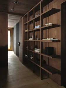 A wooden bookshelf in a home with books, vases, and bowls on the shelves, creating a cozy and inviting atmosphere
