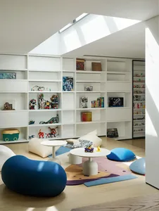 Open living area with a large bookshelf, multiple chairs, and couches, creating a cozy and inviting atmosphere