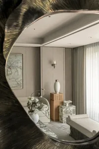 Comfortable living space with two couches, a chair, artwork on the walls, and natural light from a large window