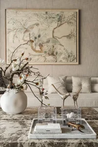 Elegant living room with furniture, decorative items, vases, potted plants, chairs, dining table, and a bird statue, featuring wood accents and natural elements