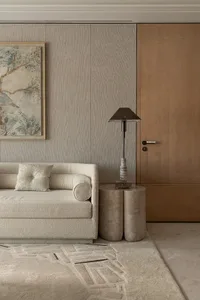 Cozy living area with a white couch, cream-colored walls, and two lamps on either side