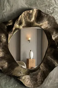 Elegant living space with a couch in front of a mirror, two vases on display, and a well-organized atmosphere