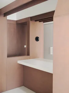 A kitchen with a wooden countertop, a mounted clock, and a warm atmosphere