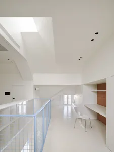 Modern open space with a staircase, two chairs, and concrete walls