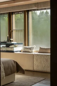 Cozy living space with natural light, wood furniture, and a dining table near a window