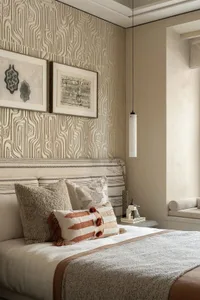 A well-lit bedroom with a striped pattern on the walls, a large bed, and two pictures above it