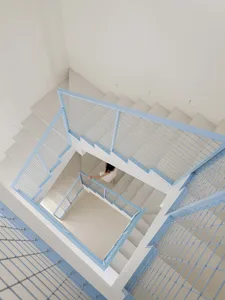 A well-lit interior staircase with metal steps, a modern and sleek design