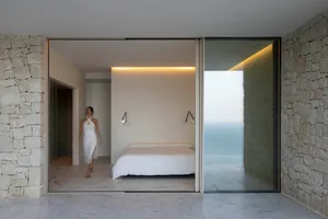 A well-lit bedroom with a large bed, two lamps, and white walls creating a comfortable and relaxing atmosphere