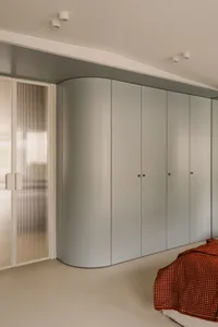 A gray closet with double doors open, showcasing its interior and storage space