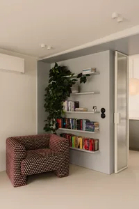 A cozy reading nook with a chair, bookshelves, and a doorway, featuring a warm and inviting atmosphere with books and comfortable seating