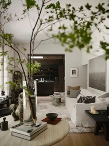Cozy living room with a grey color scheme, a couch, dining table, chairs, and natural light from a large window