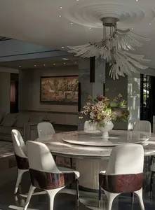 A well-designed living area with a dining table surrounded by chairs, a vase, and a couch, creating a comfortable seating arrangement