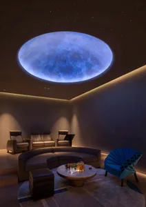 A modern living area with a round window in the ceiling, two couches, a chair, and a comfortable seating arrangement