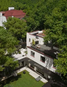A modern building with white and red colors, featuring a balcony and contemporary design elements