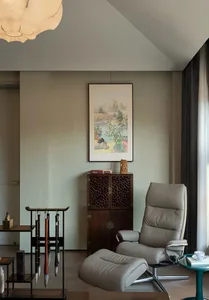 A comfortable living space with a leather chair, two smaller chairs, and a wall hanging, creating a relaxing atmosphere