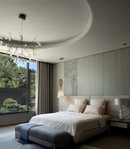 A well-lit bedroom with a white bed, two bedside lamps, and a couch, creating a comfortable and inviting atmosphere