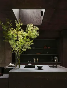 A kitchen scene with a sink, countertop, and various items arranged on the counter, creating a cozy and functional atmosphere