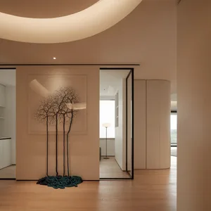 Empty modern living room with white walls, wooden floors, and natural light from a large window