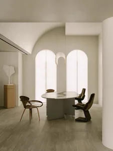Cozy modern living space with a dining table, chairs, and a couch, surrounded by natural light from a large window