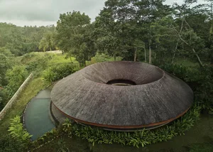 A modern house with a circular shape surrounded by trees, providing a sense of tranquility and connection to nature