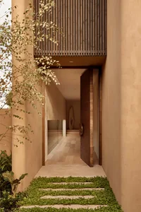 Cozy entrance with a wooden door and adobe walls, featuring a hallway with two rooms on either side