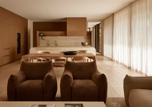 Open living area with hardwood floors, wooden cabinets, and well-lit space with furniture and a dining table