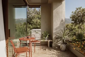 A well-lit dining area with a table, chairs, and potted plants, creating a warm and inviting atmosphere