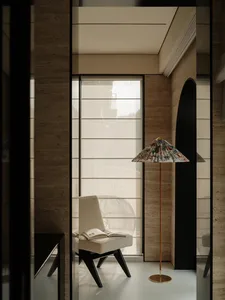 A modern living area with a chair near a window, stone walls, and a calm atmosphere