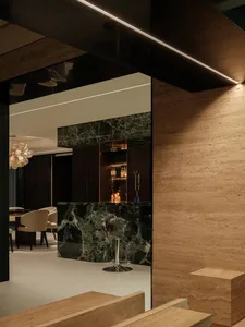 Sophisticated living space with a marble bar, two chairs, and a dining table, featuring luxurious marble accents
