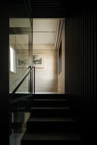 A cozy staircase with two sets of wooden steps, leading to another level of the house, with a warm and inviting atmosphere