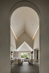 Open living and dining area with vaulted ceiling, two couches, a chair, and a dining table with chairs