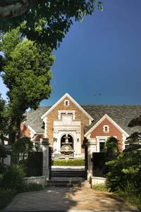 A traditional brick house with a white roof and red brick exterior, featuring a symmetrical design with multiple windows and natural light coming through the windows