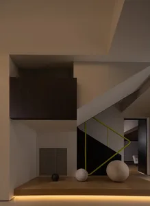 Modern staircase with wooden steps and a black railing, featuring decorative balls at the base