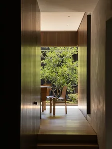A warm and inviting dining space with a table and two chairs, a potted plant, and a cozy atmosphere